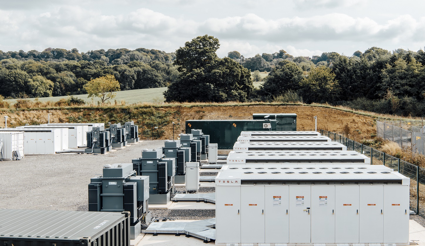 Tesla battery containers with fields and batteries in the background